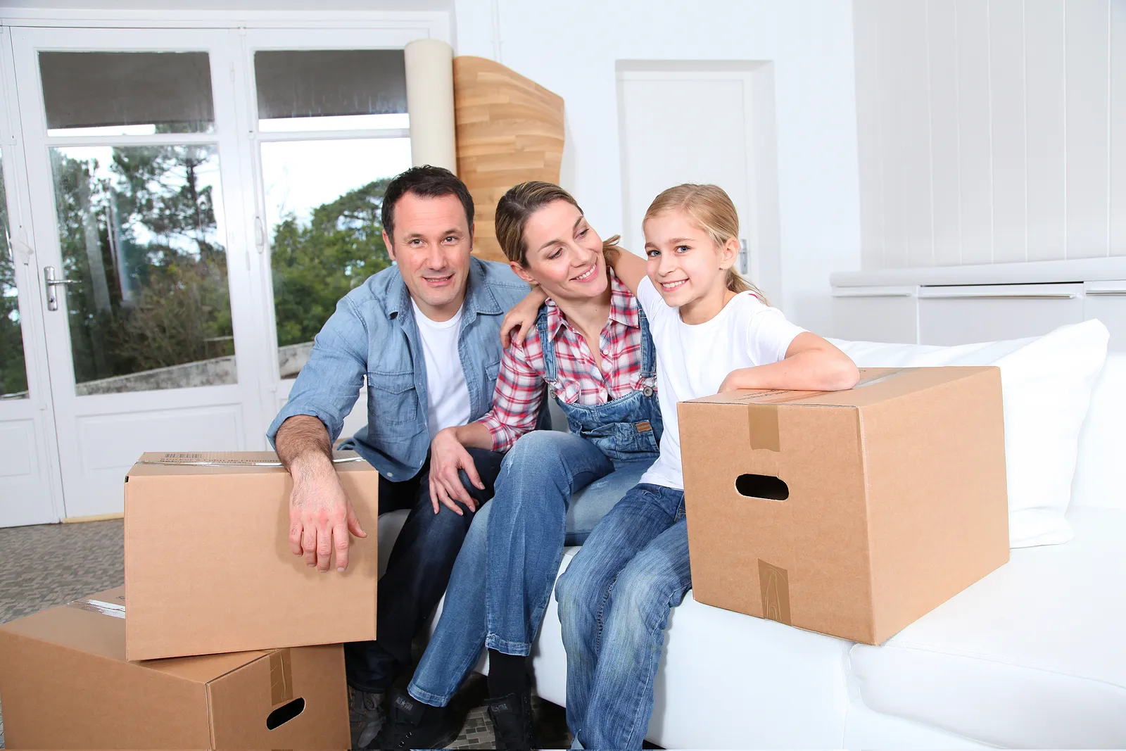 a family smiling at the camera after moving in to a new home