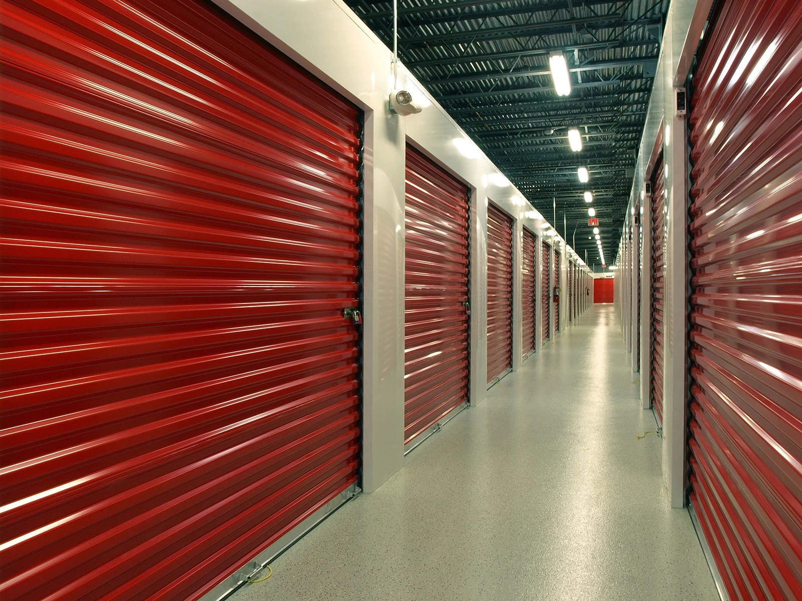 a row of closed indoor storage units with red doors